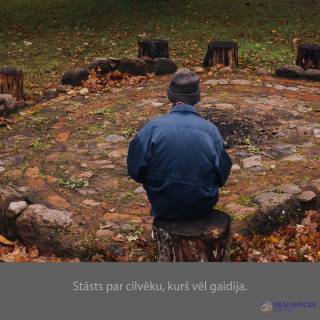 a boy sitting on ground in a yard in autumn