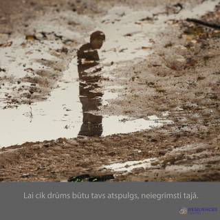 reflection of a boy in water on ground