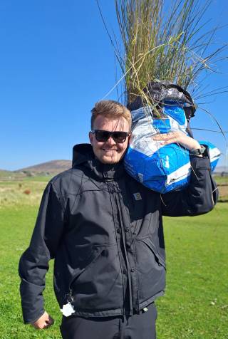 Severi Kaarnakorpi carrying a bag of marram grass.
