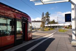 Punainen ratikka pysäkillä.