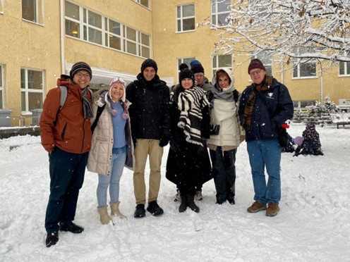 Seven people standing outside on snow.