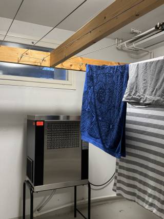 heater fan drying garments hung in the drying room