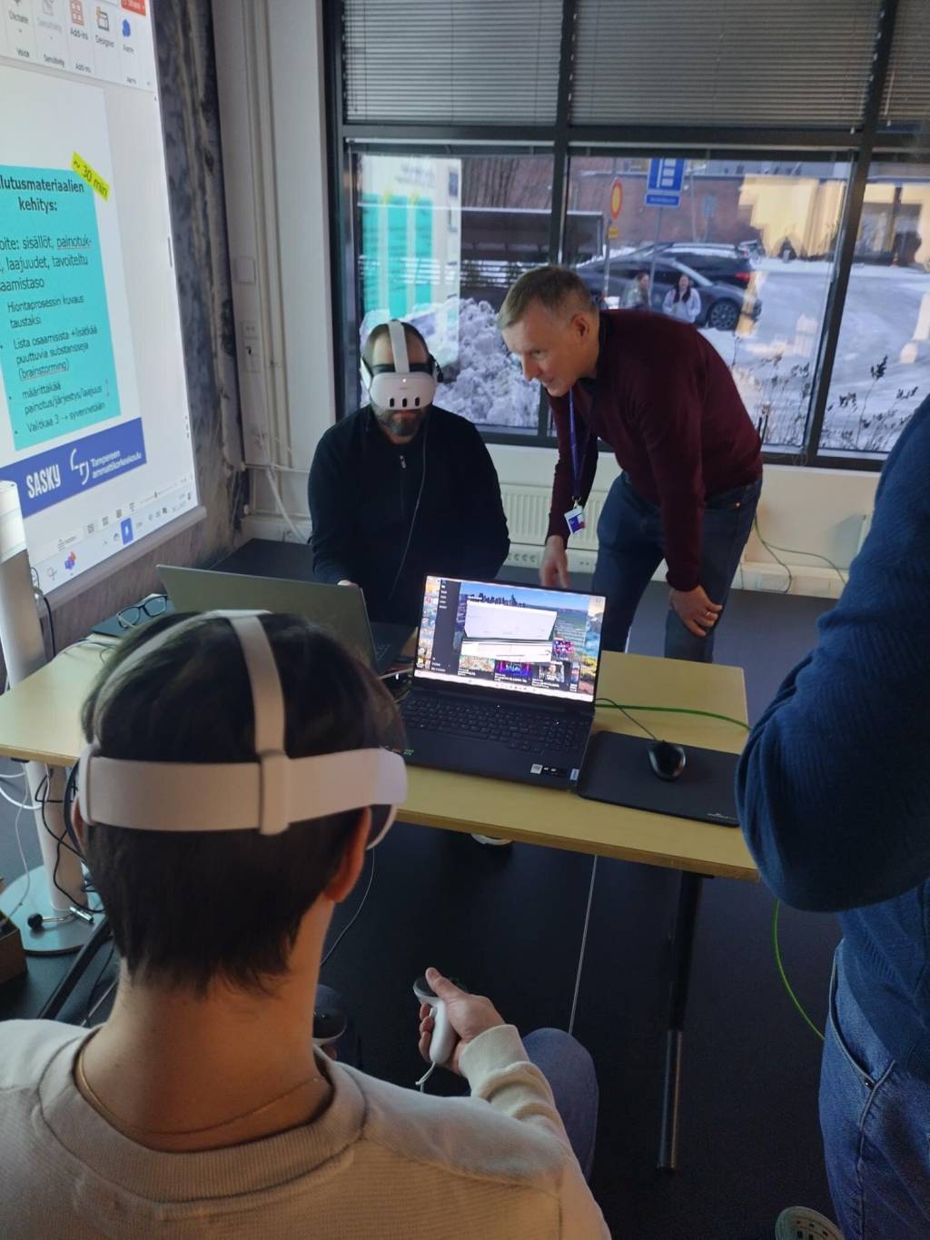 Yhteiskehittämisen työpajassa projektipäällikkö Mika Nikander opastaa VR-hiontasimulaattorin käyttöä.