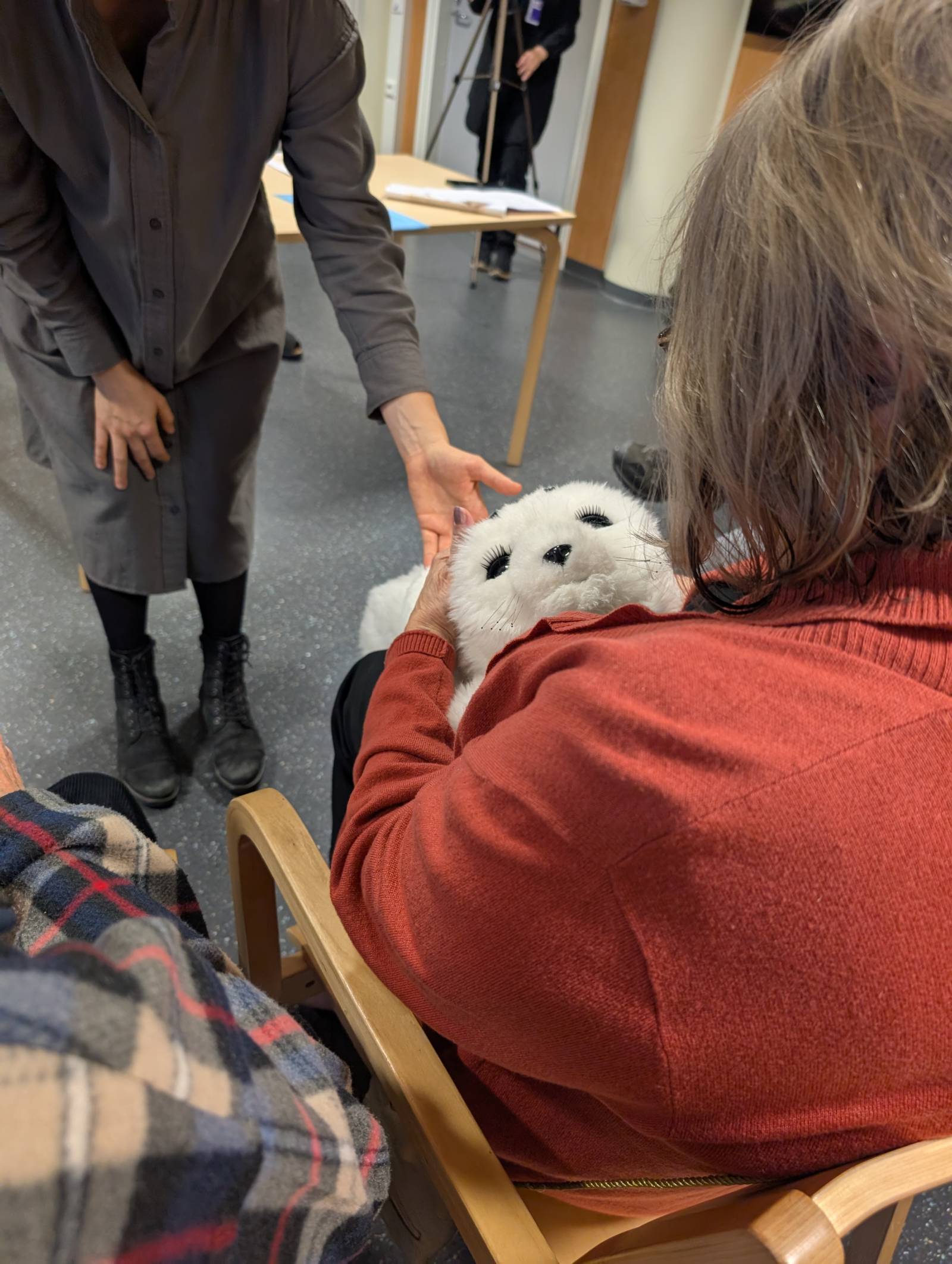 Henkilö pitelee sylissään hylje-robottia
