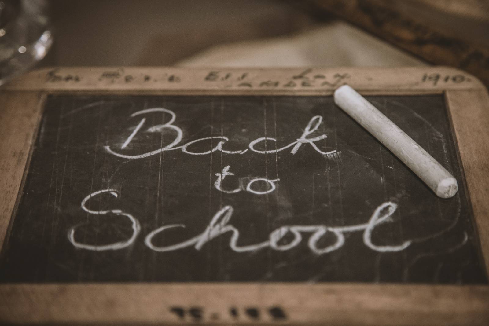 Kuva, jossa pieni liitutaulu, johon on liidulla kirjoitettu back to school -teksti.