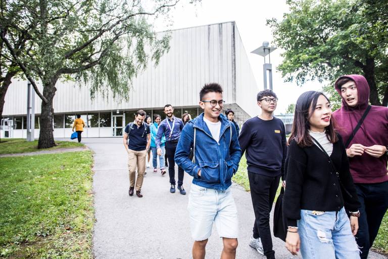 Students walking in front of the Main Building of the Tampere University Central Campus