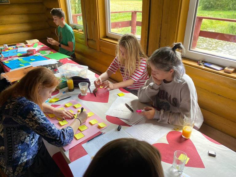 young people sitting around a desk and designing educational games