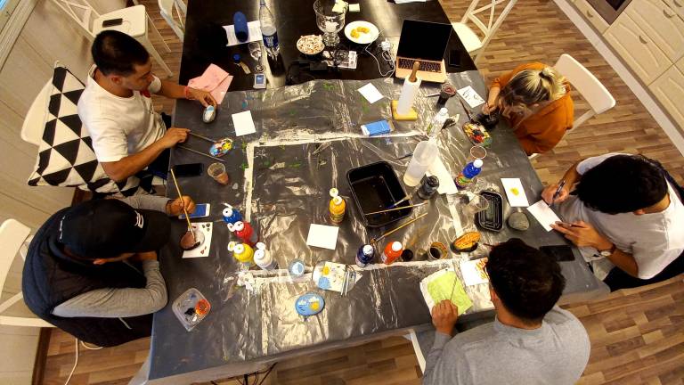 young men sitting around a table in an art workshop