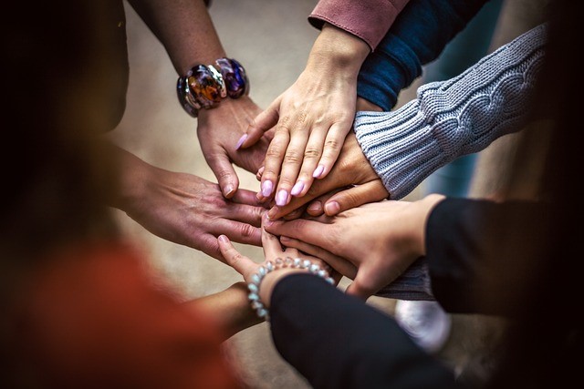 Hands reaching out towards each other in a circle.