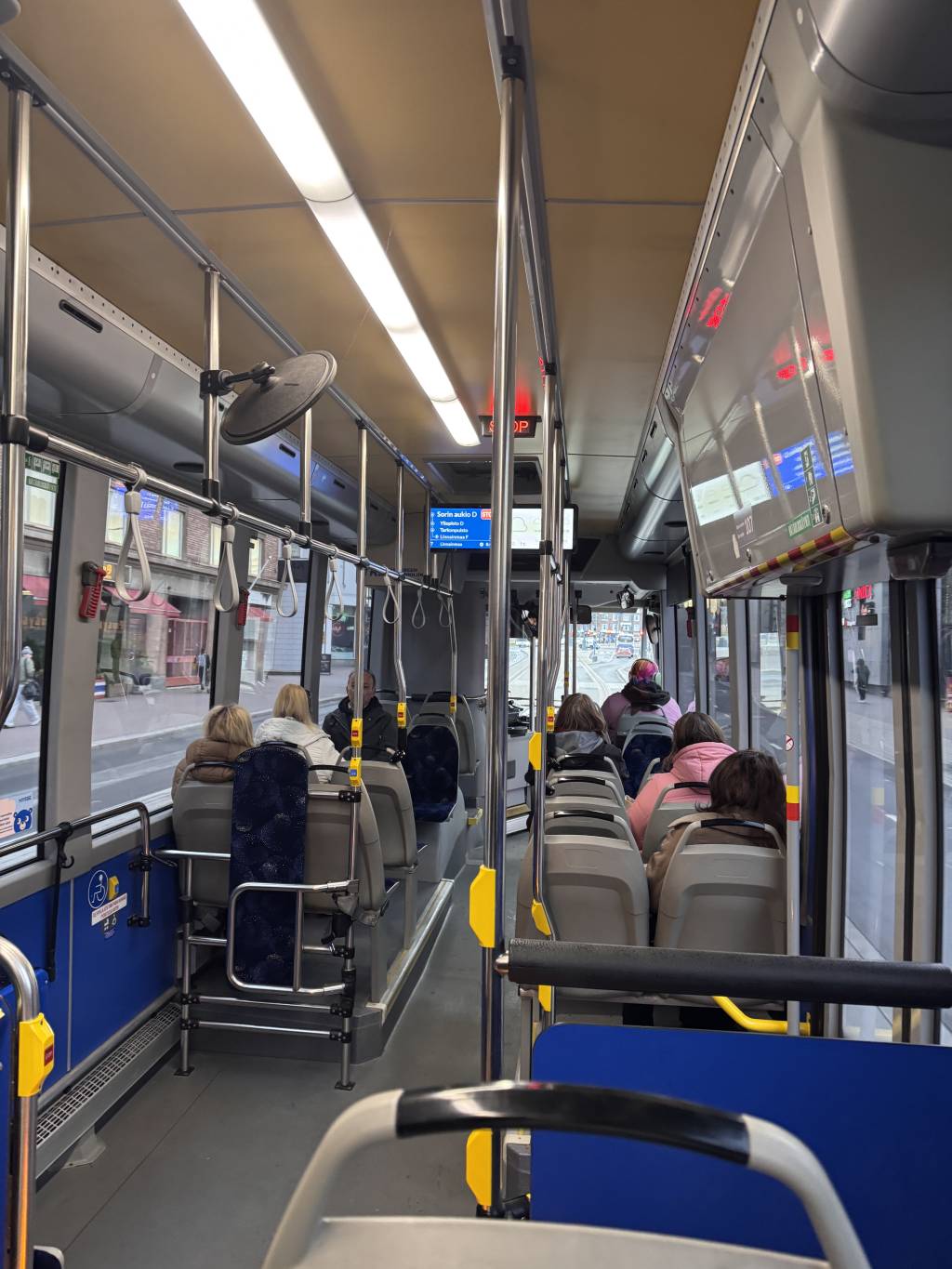 Passengers sitting quietly with space between each other on a Finnish bus.