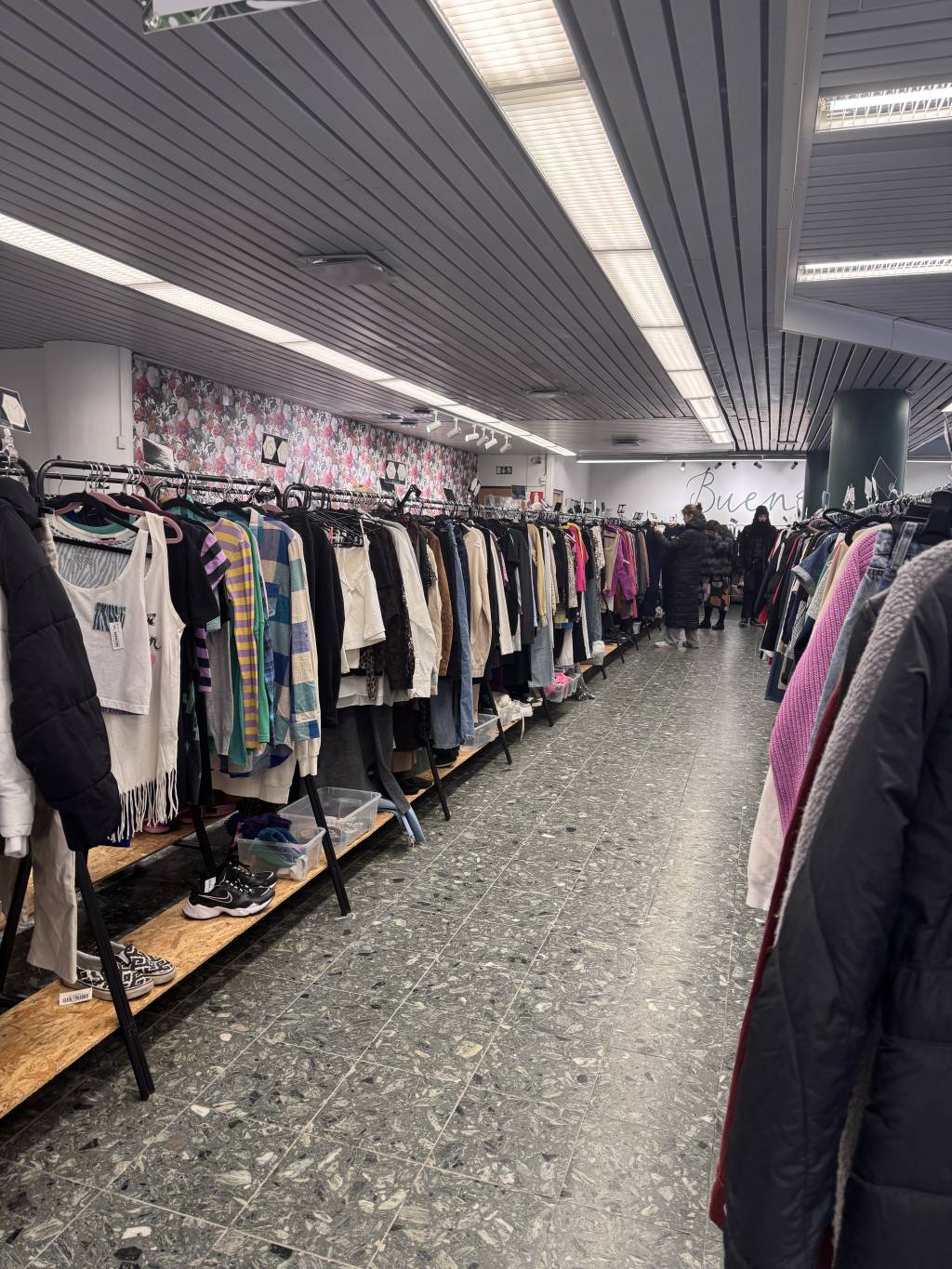 Interior of a Finnish secondhand store with clothes and everyday items on display.