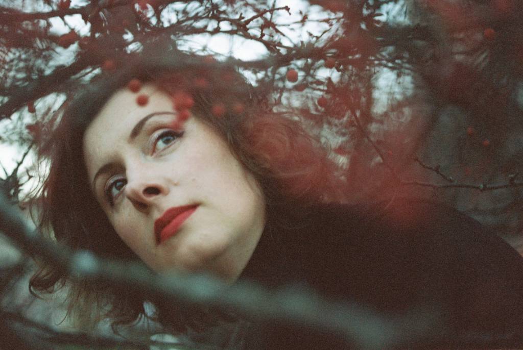 Kasvokuva puiden siimeksessä.