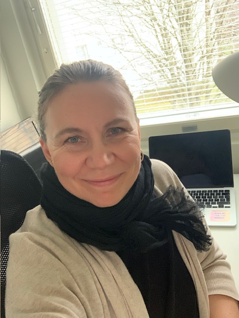 Salla hymyilee. Taustalla kannettava tietokone.