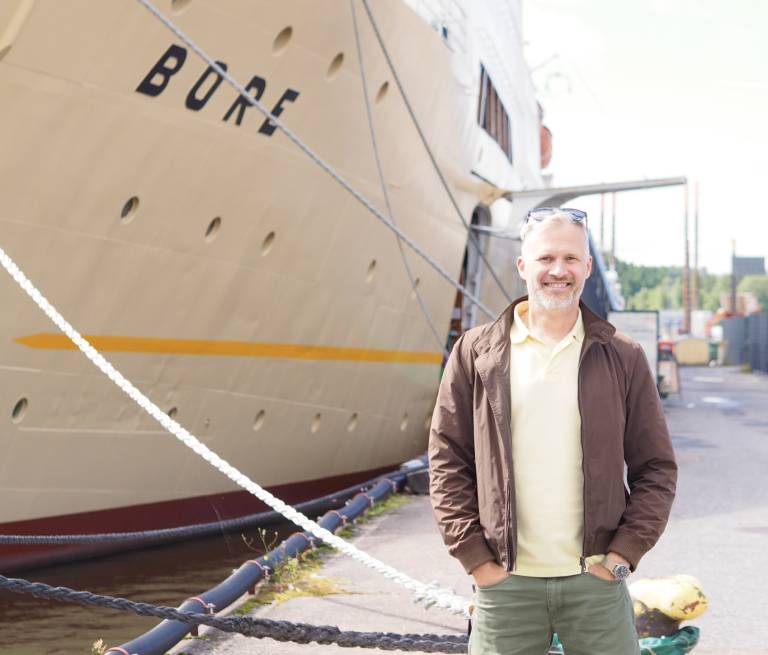 Mikko Viitanen Bore-laivan edessä Turussa. Bore toimii Turun ammatti-instituutin oppimisympäristönä ja havainnollistaa ammatillisen koulutuksen yhteyttä aitoihin työelämäympäristöihin. 