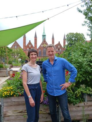 The image shows two academics standing next to each other