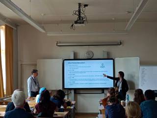 The image shows Dr Dieter Hermann Schmitz presenting the talk