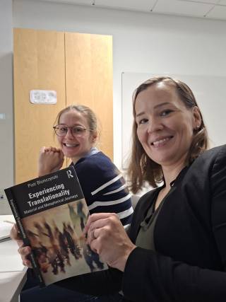 two women holding a book