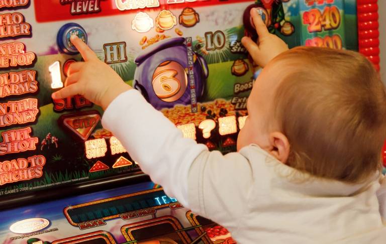 Vauva koskettelee rahapeliautomaattia.
