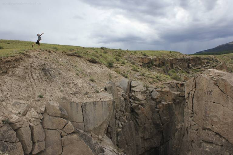 boy throwing rocks into the abyss