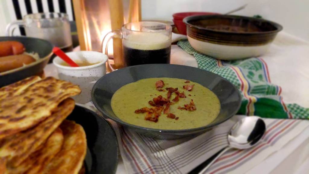 A bowl of greenish soup, sprinkled with beacon bits.