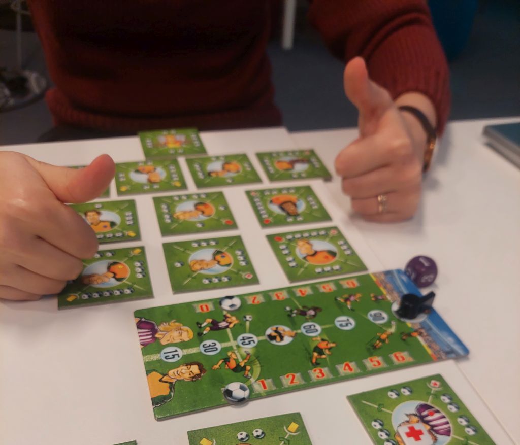 Player holding two thumbs up above a finished play session with some of the game parts showing
