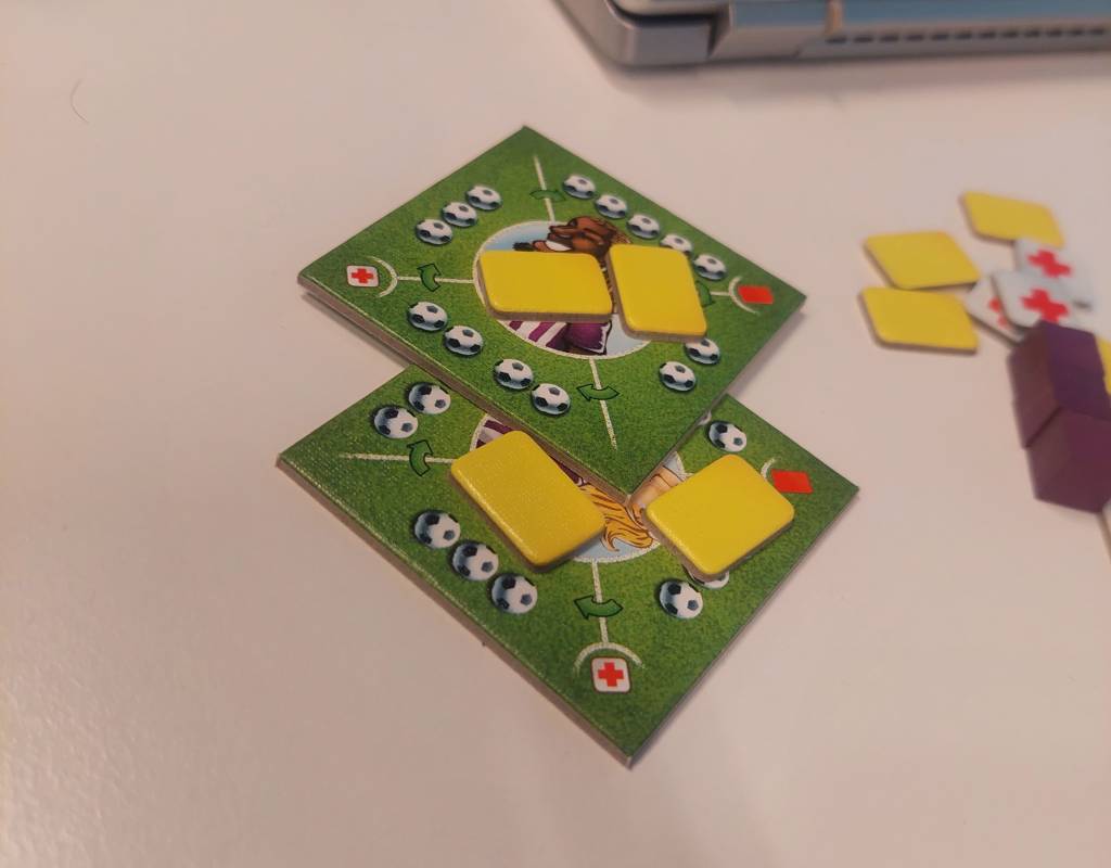 Two footballer cards with two yellow cards on top of both