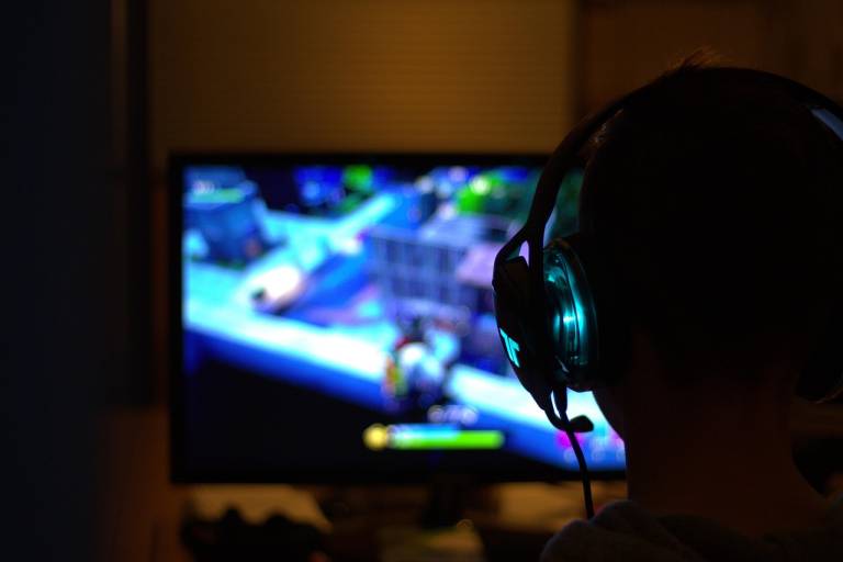 Person playing a PC game with headphones on.