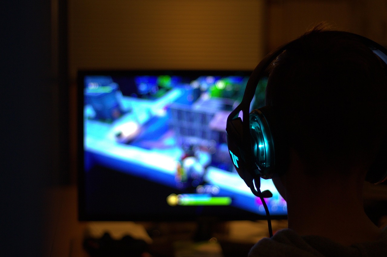 Person playing a PC game with headphones on.