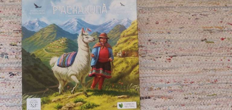 board game box with art of a white llama and a herder on a mountain site