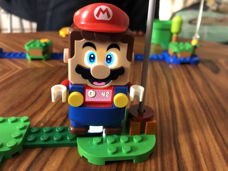 Lego Mario smiles at the camera. The chest display shows 42 coins have been collected.