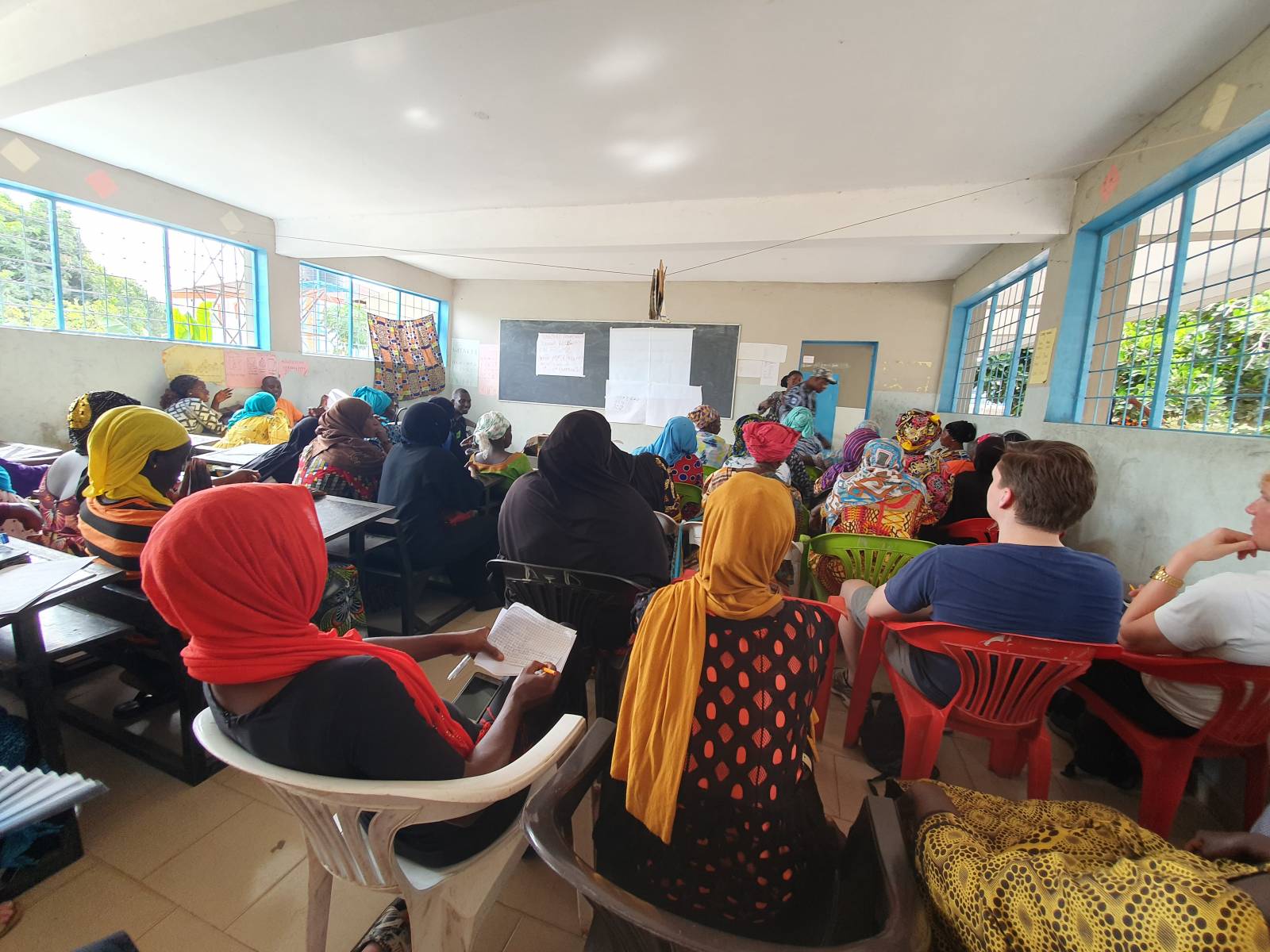 Local women listening anti-circumcition training in a class room.