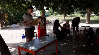 Two nursing students teaching nursery children in the garden about Impetigo.