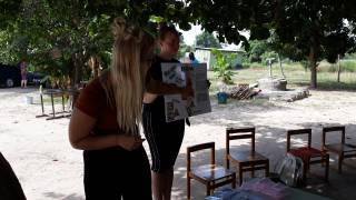 Two nursing students teaching nursery children in the garden about burns.