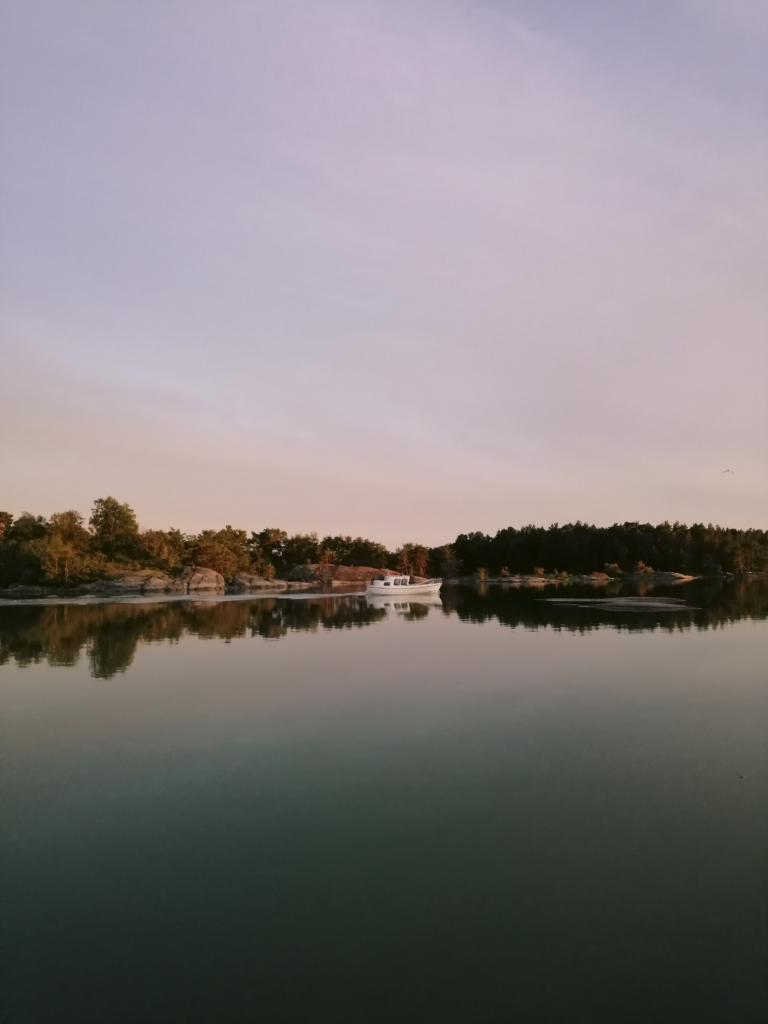 White boat in Finnish archipelago at sunset 