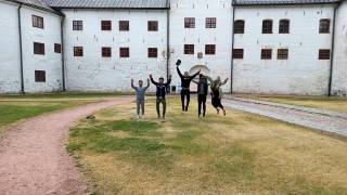 young people jumping to air in front of a castle