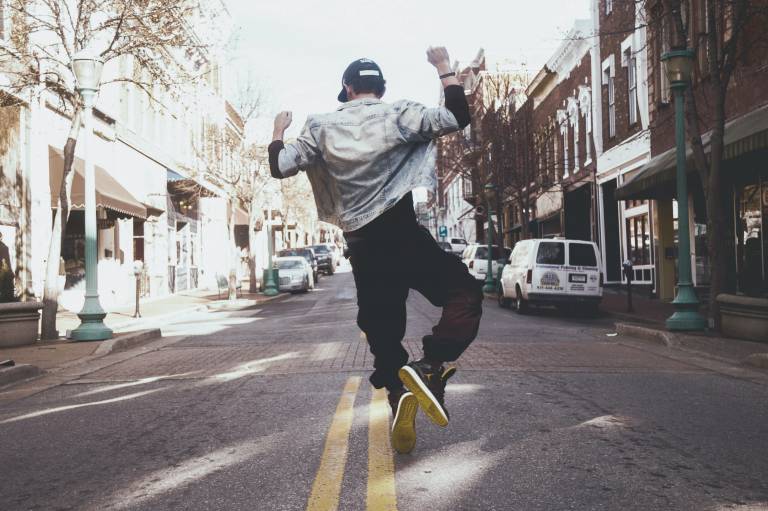 Kuva, jossa nuori hyppää ilmaan kadulla.