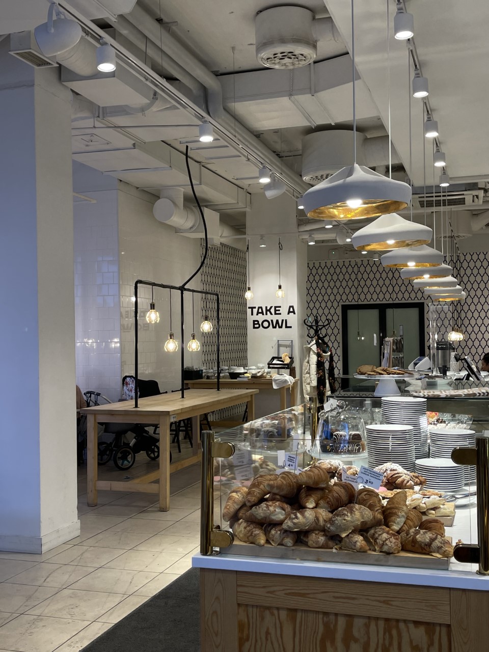 Näkymä Fazer Cafen sisätiloista ja kahvilan tiskistä, jossa myydään esimerkiksi croissanteja ja muita herkkuja.