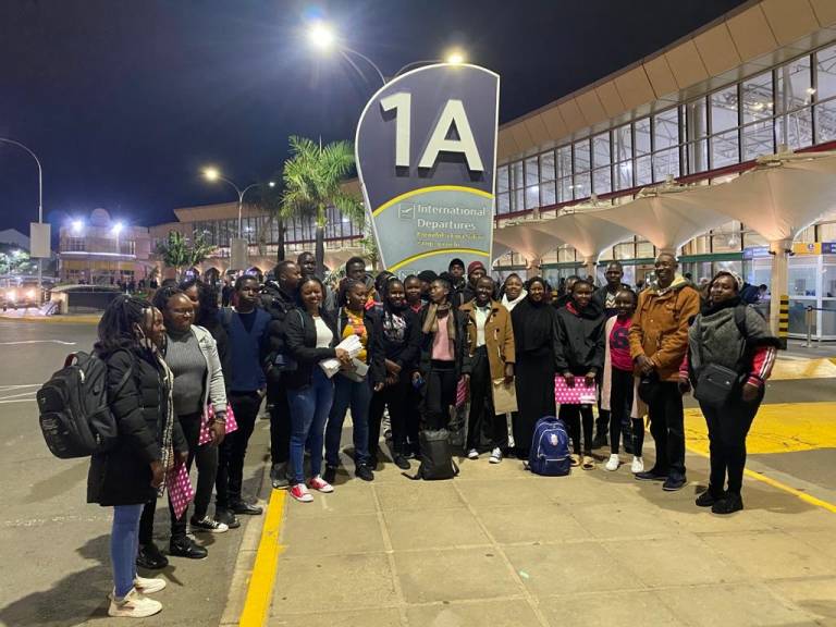 Kenyan students standing outside of an airport.