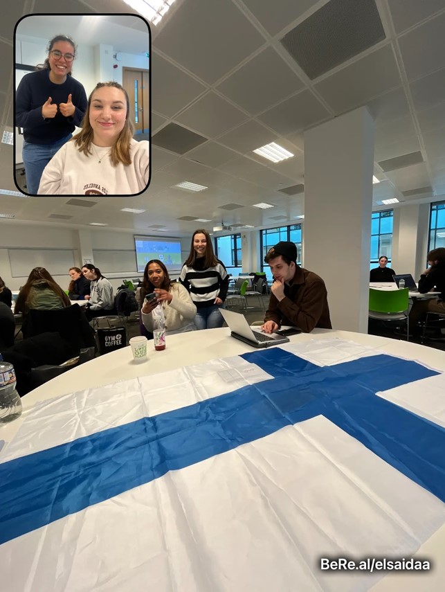 Suomen lippu liinana pöydällä ja pöydän ympärillä opiskelijoita
