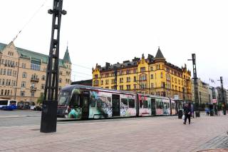 This is a photo of the downtown center. There is a tram in the center of the photo.