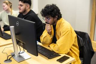 Opiskelija istuu tietokoneen äärellä.