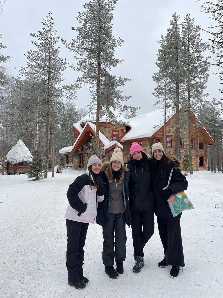 Four people standing outside in snowy Lapland.