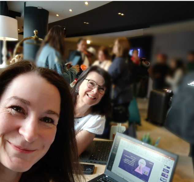 Piia Kanto and Ulla Häggblom sitting around a table with laptop on the desk.