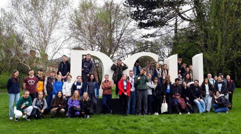Group of students from DCU, Tampere University and Utrecht University in front of a DCU sign.