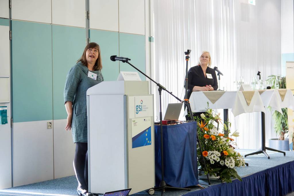 Two women standing on a stage and having a speech.