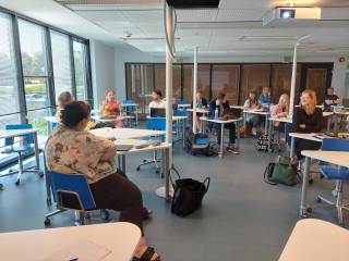 Kuva, jossa opettajia istuu luokassa keskustellen yhdessä.
