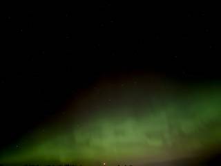 A picture of the night sky, with green northern lights and stars