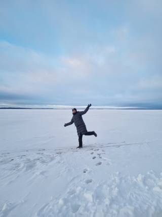 The writer rising hands standing on frozen lake.