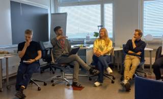 People sitting and talking in a class room.