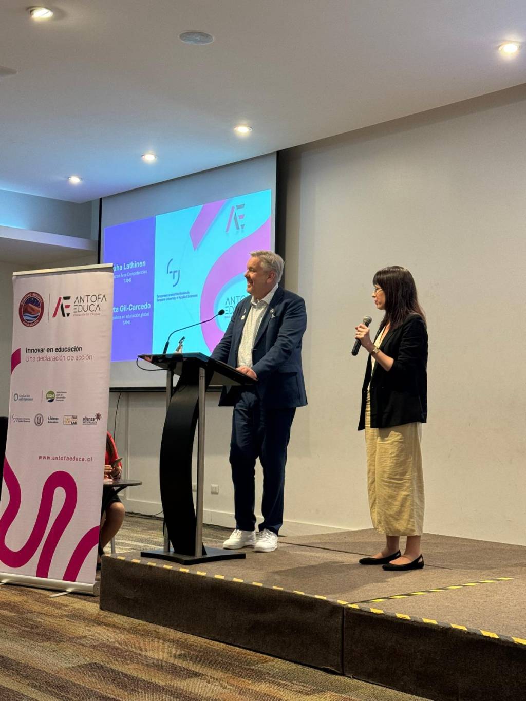 A man and a woman standing on a stage.